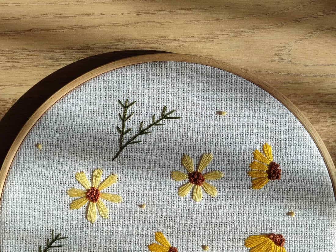 Floral embroidery stretched inside a wooden hoop - a stand-in for the Brother SAMF180N 4 x 7 in Magnetic Frame, not a photograph of this model