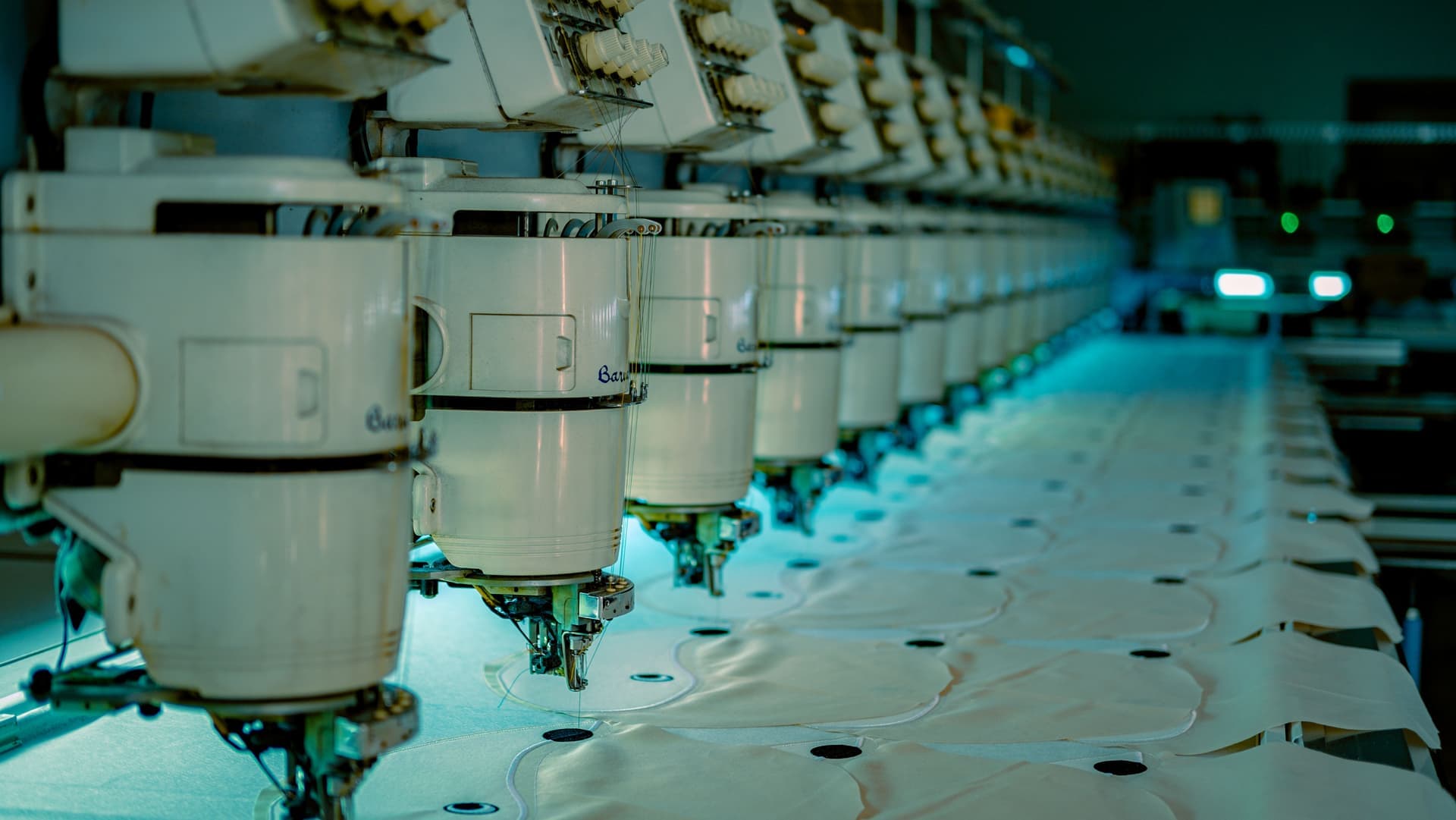 A row of industrial sewing machines in a textile workshop - a stand-in for the Brother Entrepreneur PR680W, not a photograph of this model