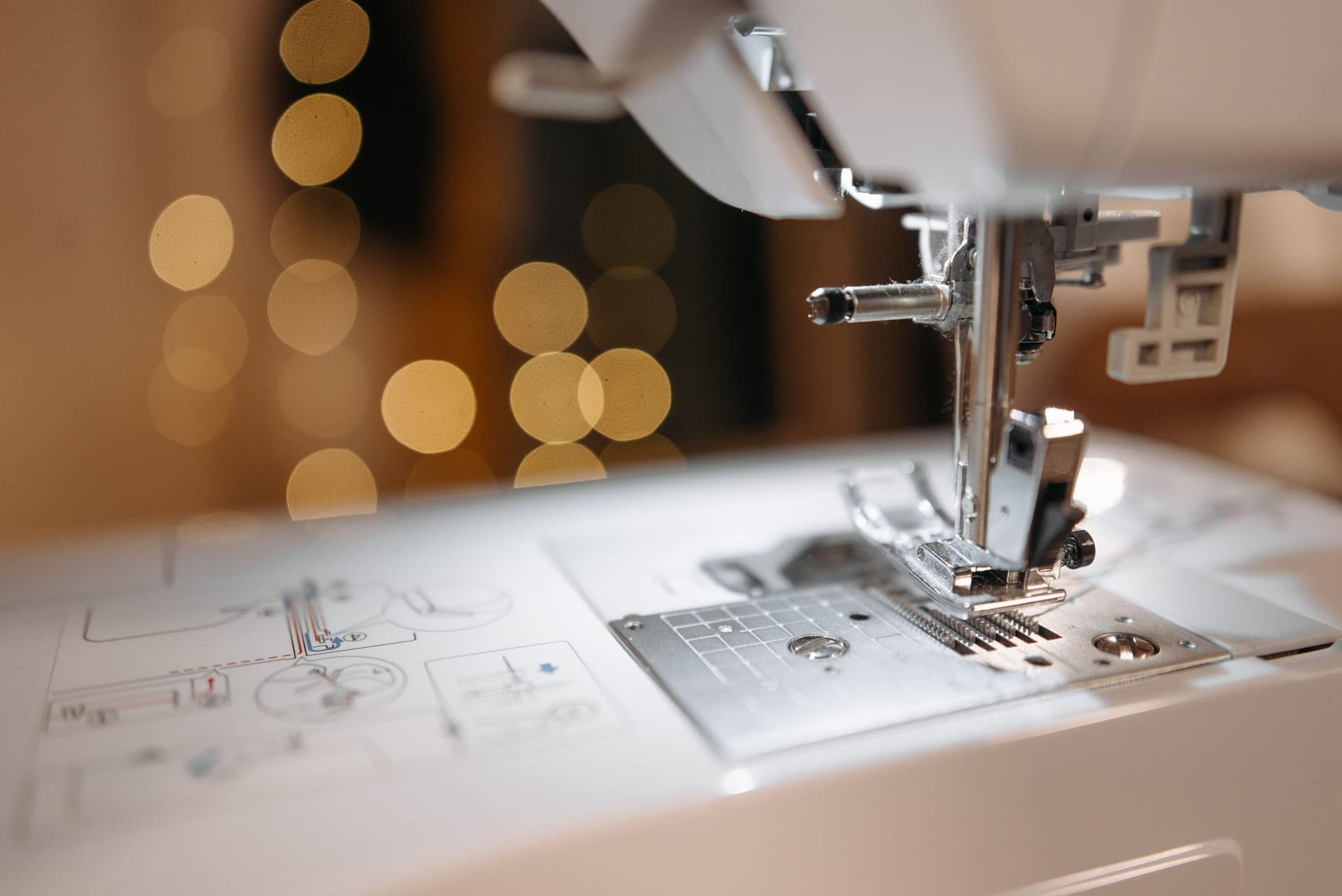 Close-up of a sewing machine needle plate and the arm above it