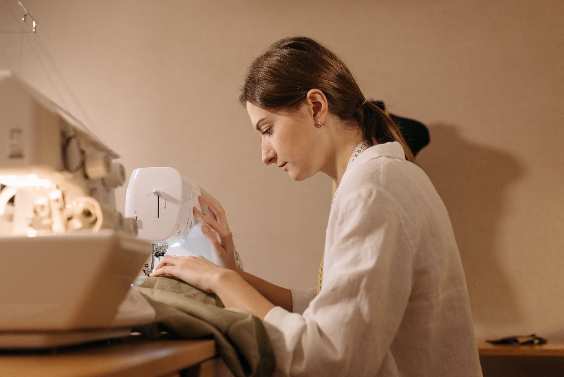 A person guiding fabric through a domestic sewing machine