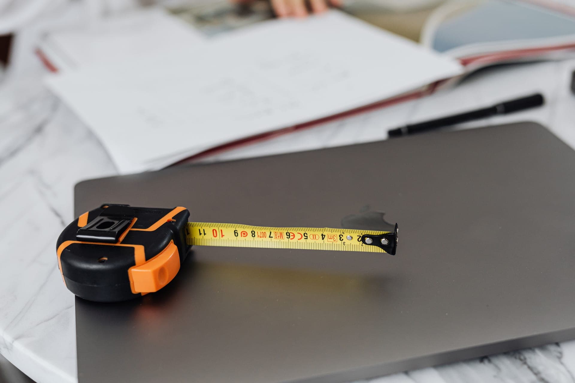 A black and yellow measuring tape on a plain work surface